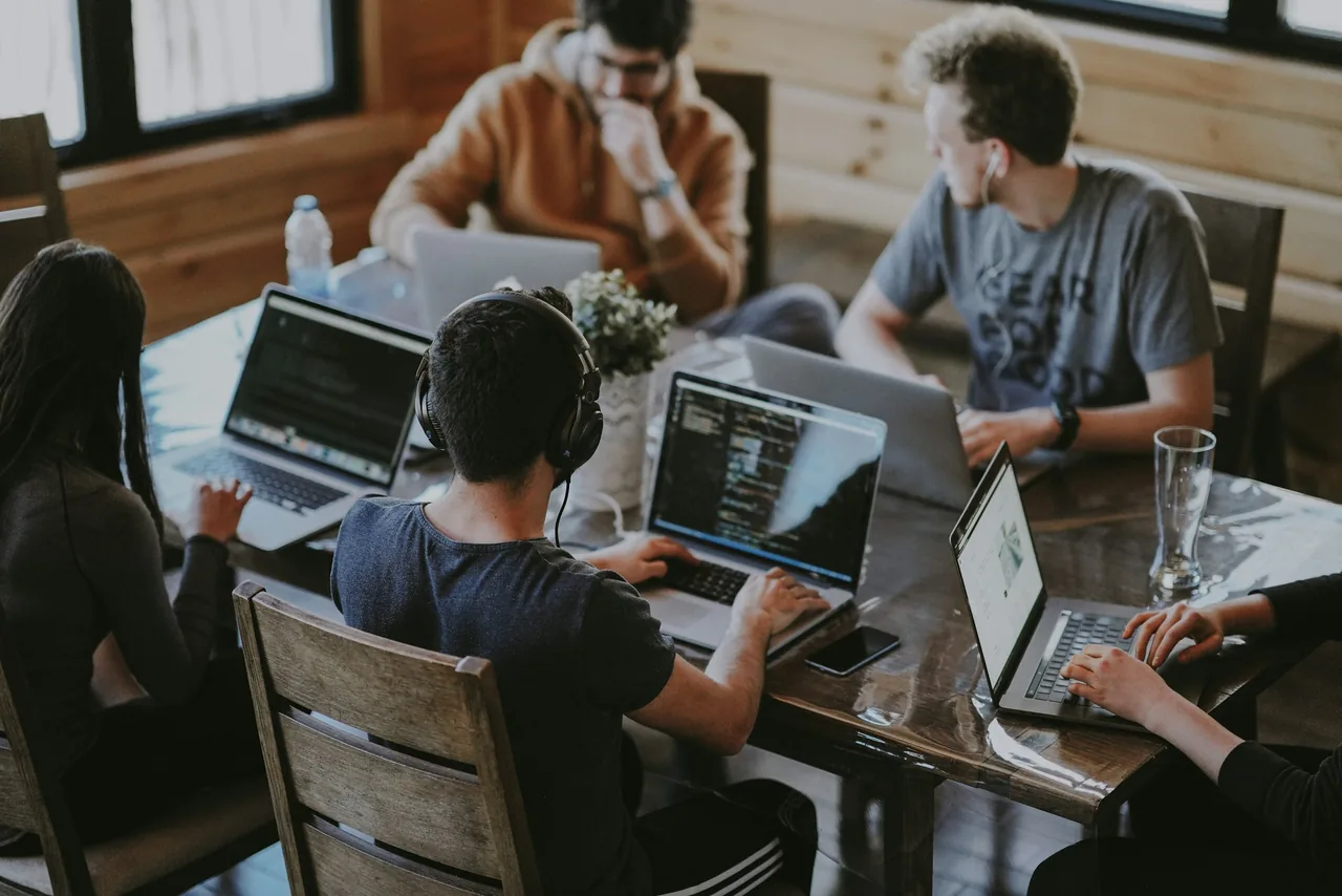 Equipo de software trabajando de forma colaborativa alrededor de una mesa